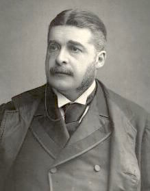 Head and shoulders of Sullivan, dressed in a dark suit, facing slightly left of center, with moustache and long sideburns. Black and white.