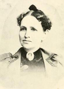 A younger white woman, wearing a portrait brooch at her throat.