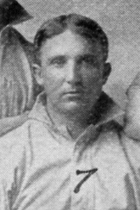 A man in a light baseball uniform.