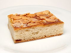 A slice of butter cake garnished with sliced almonds