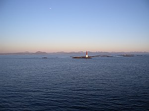 Lighthouse with fishing village in background