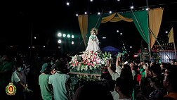 The image of our Lady wearing her traditional wedding dress, accompanied by the dancers of the parish.