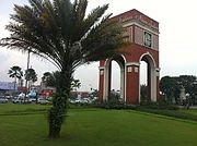 An arch and a palm tree near a shopping center