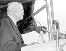 A man (former President Herbert Hoover), speaking behind a podium
