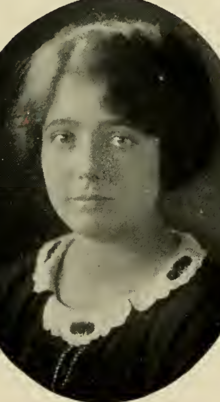 A yearbook photograph of a young white woman, wearing a dark garment with a white lace collar