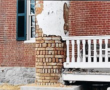 One column made of brick and plaster in a dilapidated state.