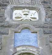 Photograph of the inscription and relief above the tower's entrance