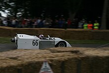 A mid-engined two-seater open-top sports car with spats covering the rear wheels and a pair of large fans sticking out the back