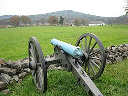 Photo shows an M1841 12-pounder howitzer at Gettysburg National Military Park with Round Top on the horizon.