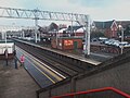 Sandbach railway station from the footbridge; passengers wait for the train bound for Piccadilly.