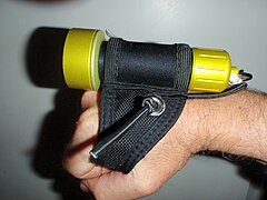 Small dive light on soft Goodman type handle, side view, showing use of handle