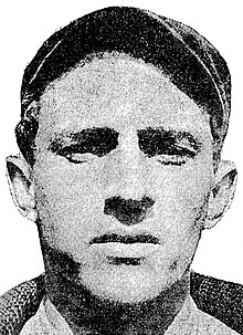 A man wearing sweater and dark baseball cap