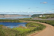 The Dempster Highway approaching the MacKenzie River ferry crossing, from the south, with buildings of Tsiigehtchic visible to the right