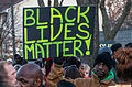 Image 33An activist holds a "Black Lives Matter" sign outside the Minneapolis Police Fourth Precinct building following the officer-involved killing of Jamar Clark on November 15, 2015 (from Black Lives Matter)