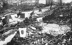 Japanese soldiers take shelter behind debris at the outskirts of Shanghai.