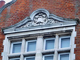 Window pediment with carved fire helmet and axe