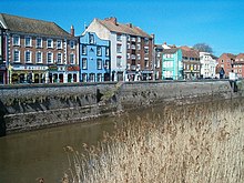 Three and four-storey buildings on the far side of a river.