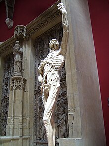 Replica of the skeleton before a large marble monument