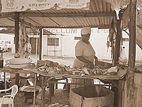 Woman selling meat, one of the many trades in the town.
