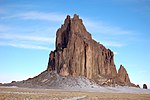 Solid rock spire protruding from the desert.
