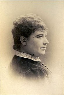 A middle-aged white woman's head and shoulders, in a sepia-toned portrait.