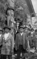 Musqueam people with house post in background.