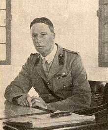 Collins in military uniform, seated at a desk.