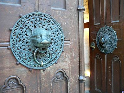 A pair of door handles, aged green bronze picturing a lion head.
