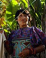 A Kuna woman wearing a mola stands next to a clothes line in Kuna Yala, Panama.