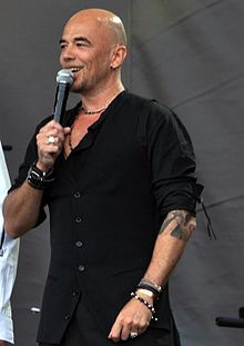 Obispo performing on stage in Paris on Bastille Day 2011