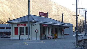 Station shelter with station sign next to railway line