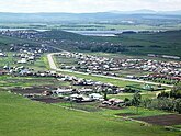 Photograph of village with main road and homes and buildings flanking it