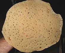 Round, thin bread with many bubbles and holes.