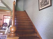 Staircase leading to the second floor of the Manistee Mansion .