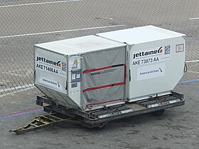 A large dolly holding two aircraft cargo Unit Load Devices for American Airlines.