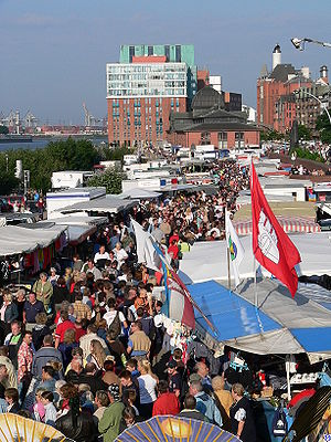 A market overview with sale booths and a large group of people.