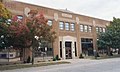 Front of red brick building with main entrance and trees