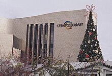 Library building with a tall Christmas decorated with snowflakes and a bow at the top