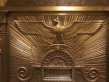 Detail of a gilded mailbox in the lobby, with an eagle carving