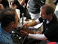 A medical student using a sphygmomanometer to measure blood pressure from the brachial artery's pulse.