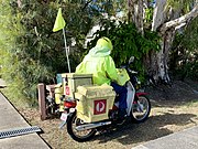 A "postie" delivering mail on a motor bike