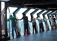 2014 interior view of tourists on the TILT Thrill Ride, with the attraction in its outward-leaning position