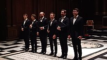 line-up of young men in black suits