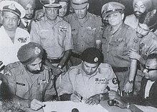 The signing of the instrument of surrender by Pakistani officers with Indian officers officiating