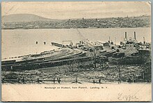 Postcard view of a rail yard and ferry terminal on the bank of a wide river