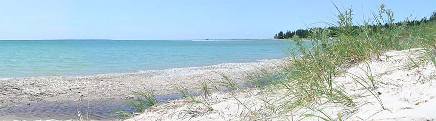 A beachfront on Iron Ore Bay on the southern shore of Beaver Island, with North Fox Island distantly visible in the left background.