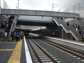 A railway station with a train and crowds of people