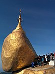 Upāsaka adding gold leaf to the rock