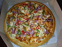 A pizza with paneer and vegetable toppings from India