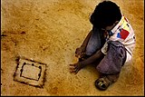H-20. (Marbles) A boy playing a game of traditional marbles in a Gujarat village.